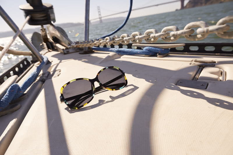 Sunglasses with multicolored frames resting on a boat.