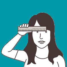 Woman with long hair holding a ruler horizontally against her forehead.