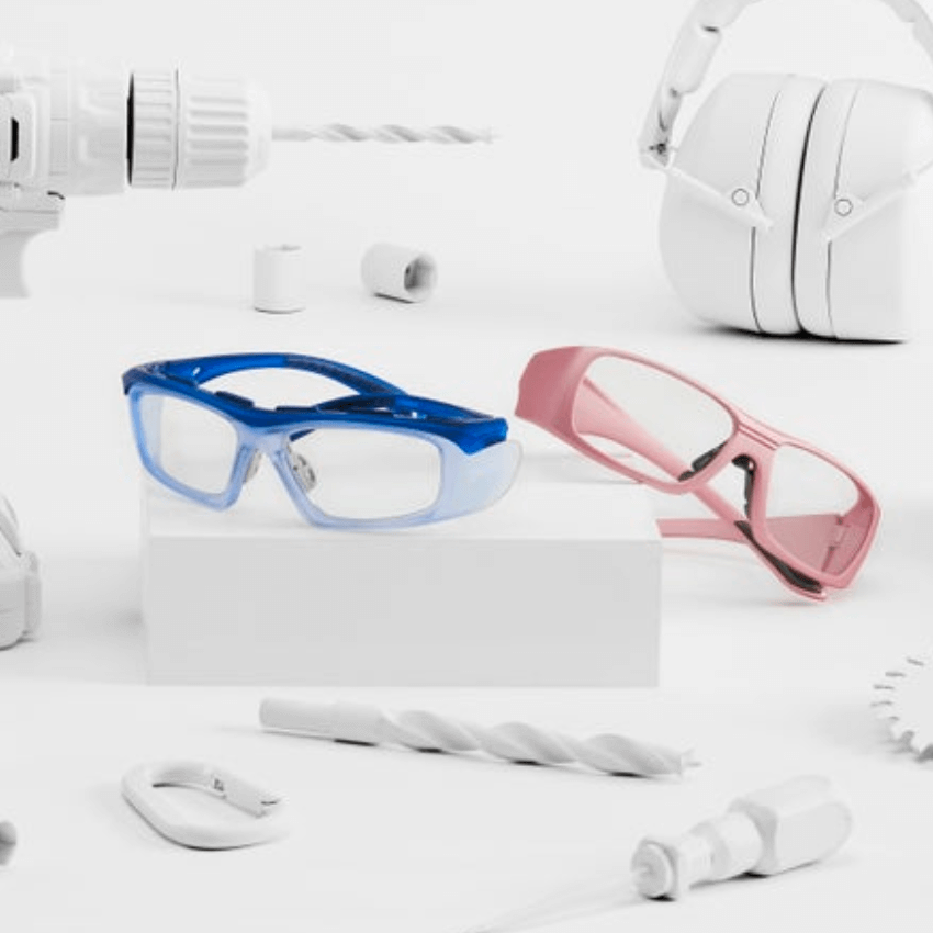 Blue and pink protective goggles displayed on a white surface.