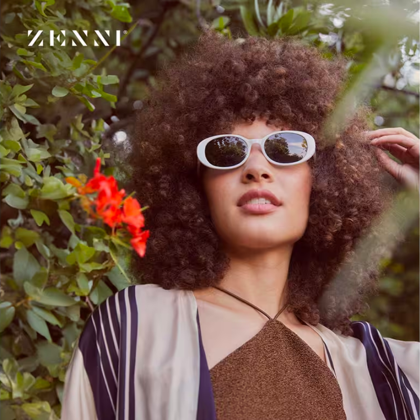 Zenni eyewear, white-framed sunglasses worn by a person with curly hair.