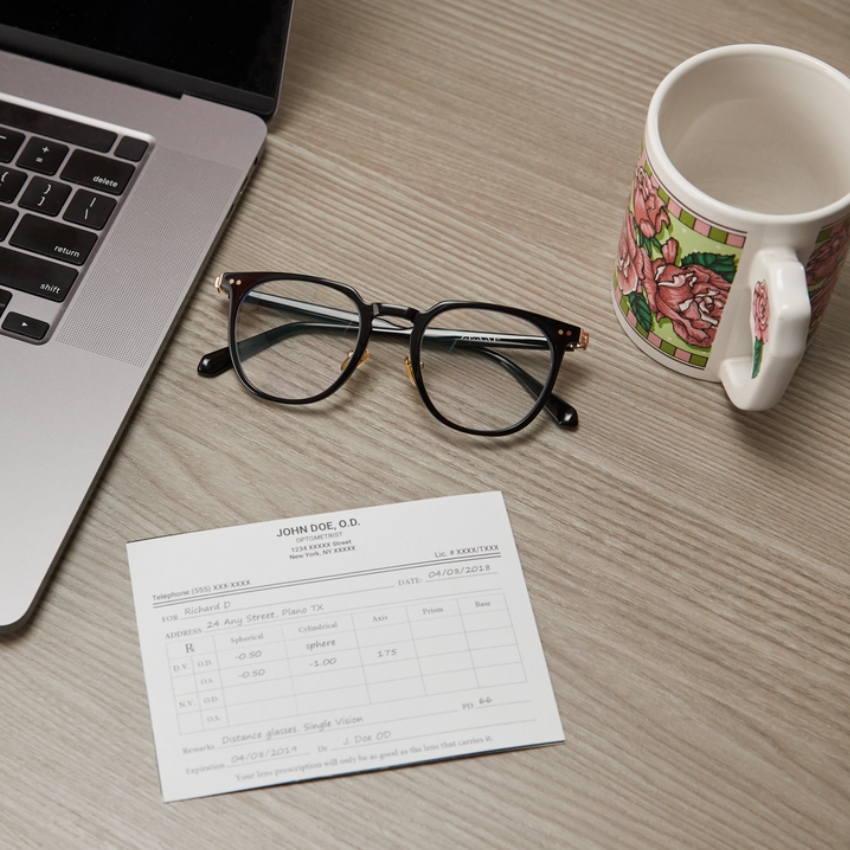Prescription eyeglasses next to an eye prescription form from John Doe, O.D. dated 04/08/2018.