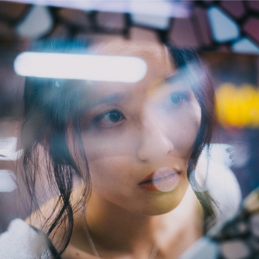 Woman's face reflected in fragmented glass.